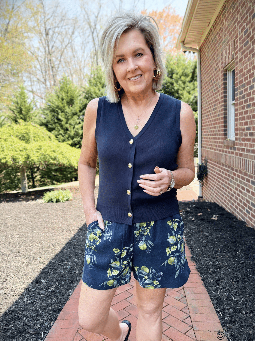 Tania Stephens wearing a navy vest with gold buttons and shorts with lemons from Walmart